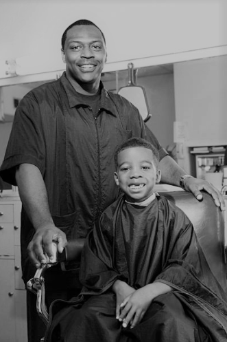 a pic of a barber standing beside his client